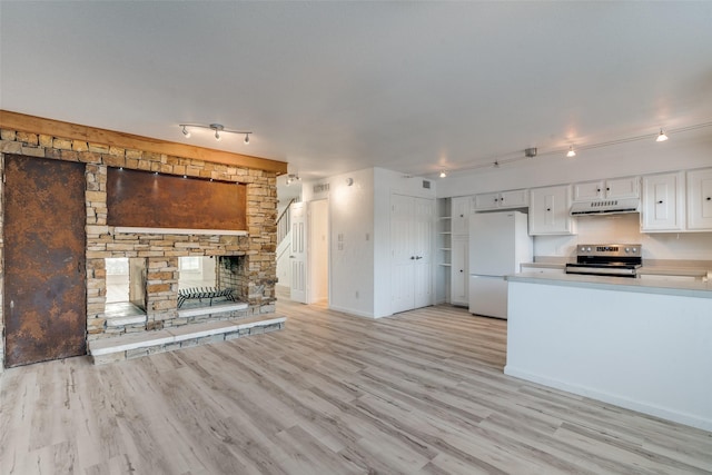 kitchen featuring light hardwood / wood-style flooring, electric range, white refrigerator, a fireplace, and white cabinets