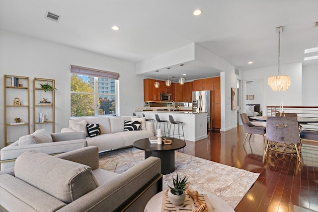 living room featuring dark hardwood / wood-style floors and a notable chandelier