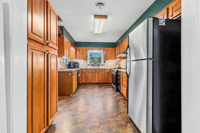 kitchen with appliances with stainless steel finishes, sink, and a textured ceiling