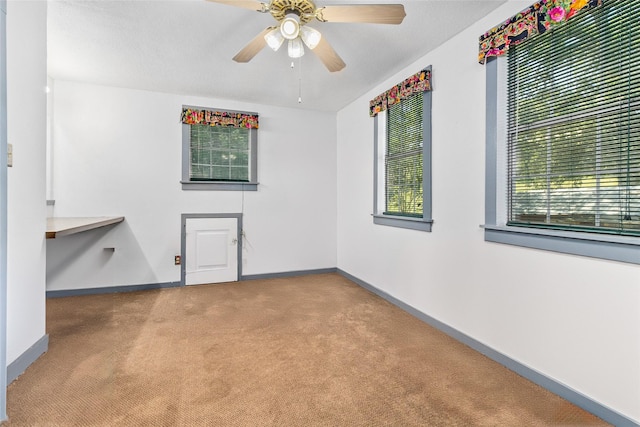 spare room with light colored carpet and ceiling fan