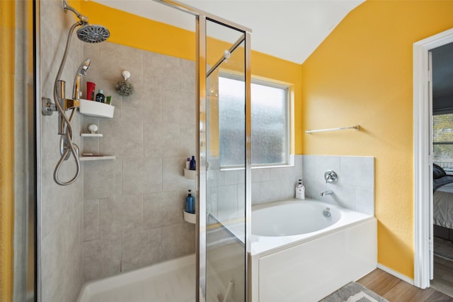 bathroom featuring hardwood / wood-style floors, independent shower and bath, and lofted ceiling