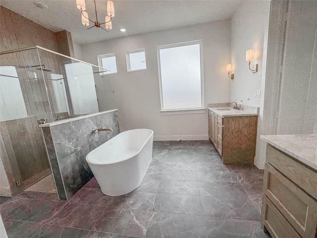 bathroom featuring vanity, separate shower and tub, and an inviting chandelier