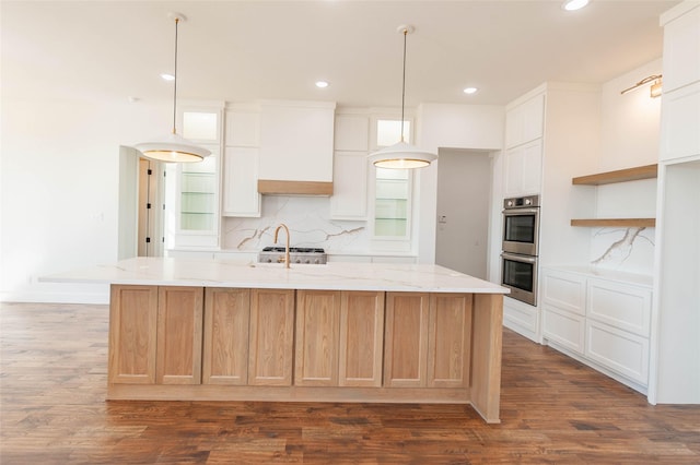 kitchen featuring decorative light fixtures, white cabinets, custom exhaust hood, a large island, and stainless steel double oven