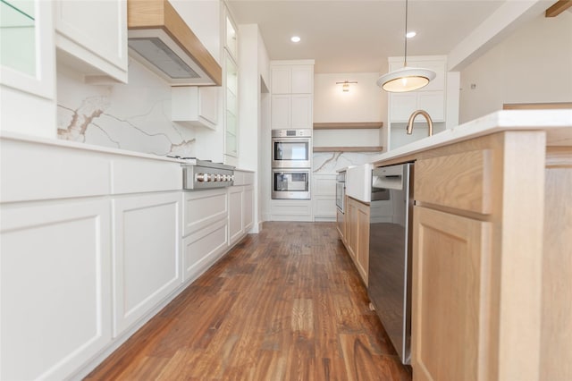 kitchen with appliances with stainless steel finishes, dark hardwood / wood-style floors, custom range hood, white cabinets, and decorative backsplash