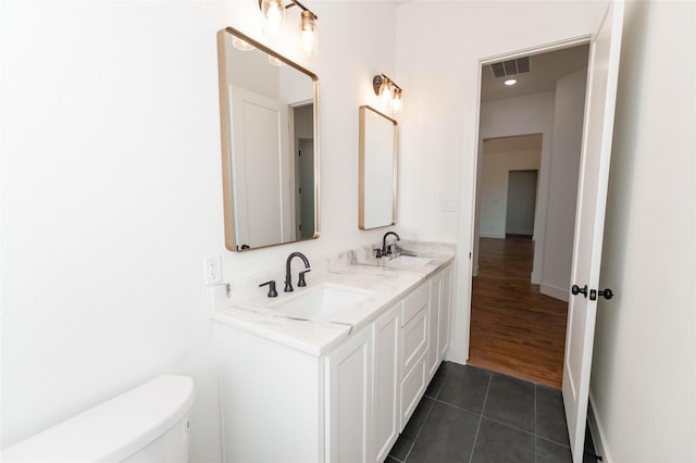 bathroom featuring tile patterned flooring, vanity, and toilet