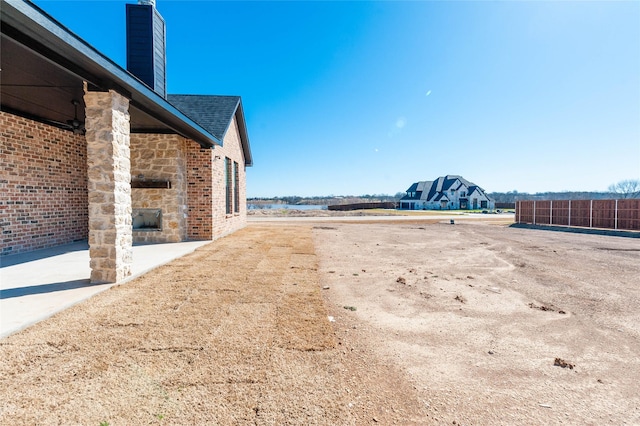 view of yard featuring an outdoor stone fireplace