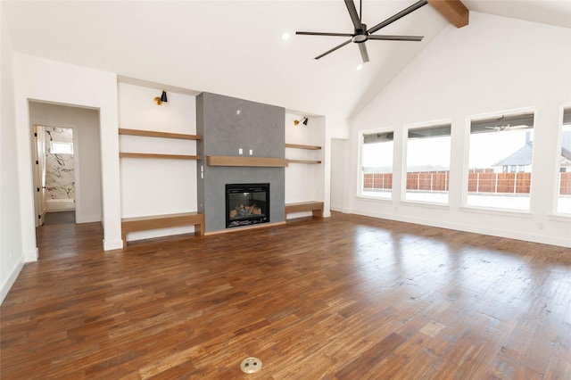 unfurnished living room featuring beam ceiling, ceiling fan, a fireplace, and dark hardwood / wood-style flooring