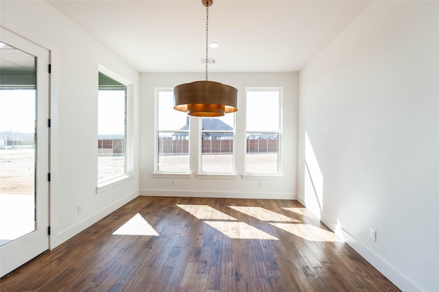 unfurnished dining area with a healthy amount of sunlight and dark wood-type flooring