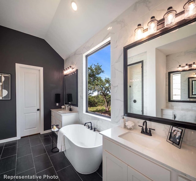 4121 Buffalo Clover Dr, Aubrey, TX 76227 - bathroom featuring a soaking tub, two vanities, vaulted ceiling, tile patterned floors, and tile walls