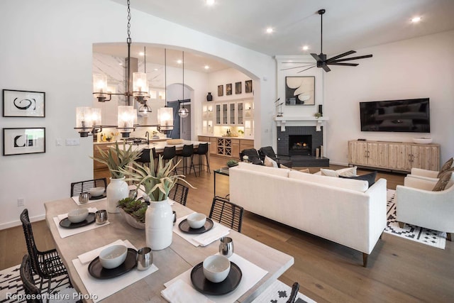 4121 Buffalo Clover Dr, Aubrey, TX 76227 - dining space with ceiling fan, a chandelier, wood finished floors, recessed lighting, and arched walkways