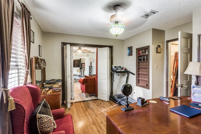 office space with a textured ceiling and light hardwood / wood-style floors