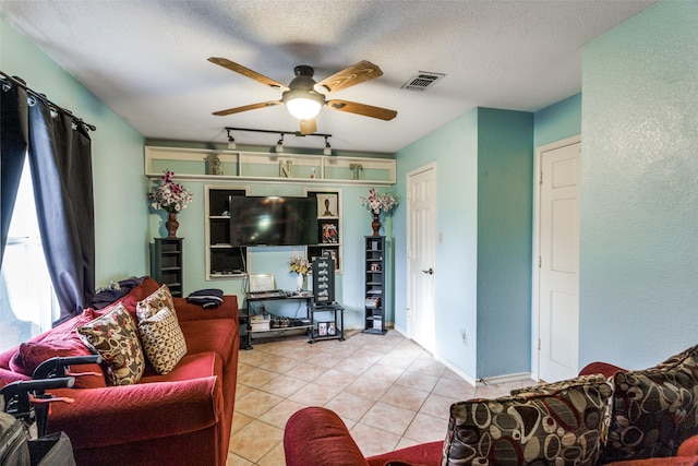 tiled living room with a textured ceiling and ceiling fan