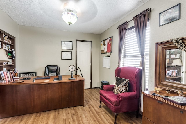 office area featuring ceiling fan, light hardwood / wood-style flooring, and a textured ceiling