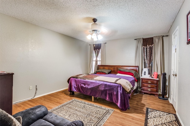 bedroom featuring wood-type flooring, a textured ceiling, and ceiling fan