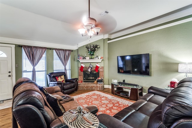 living room with a fireplace, ceiling fan, hardwood / wood-style floors, and ornamental molding