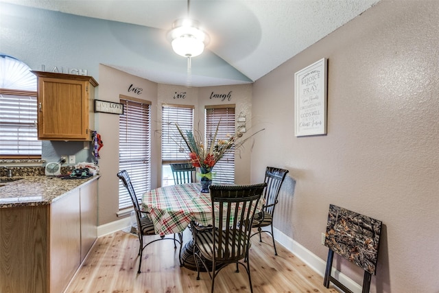 dining area featuring light wood-type flooring, ceiling fan, and lofted ceiling