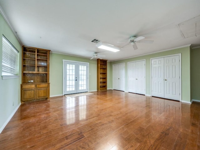 unfurnished living room with hardwood / wood-style flooring, crown molding, ceiling fan, and french doors