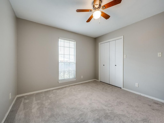 unfurnished bedroom with light colored carpet, a closet, and ceiling fan