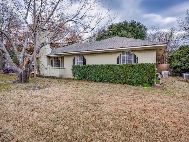 view of front of home featuring central AC unit and a front yard