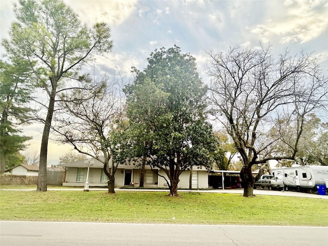 view of front of house with a carport and a front lawn