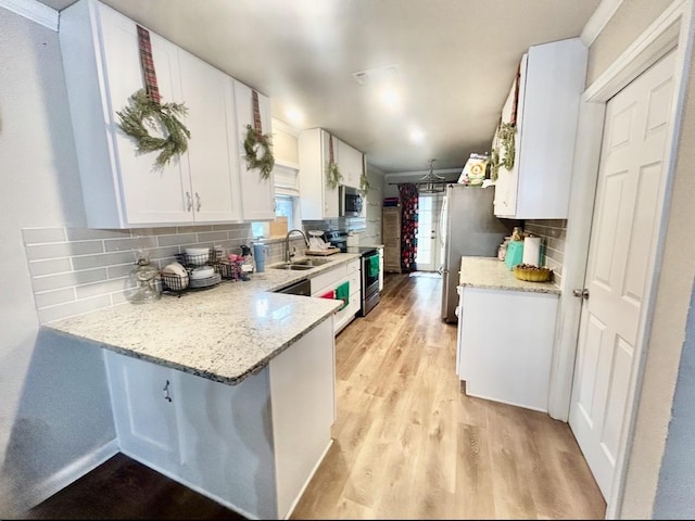 709 Kerry Ln, Azle, TX 76020 - kitchen with appliances with stainless steel finishes, light wood-type flooring, white cabinets, backsplash, and a peninsula