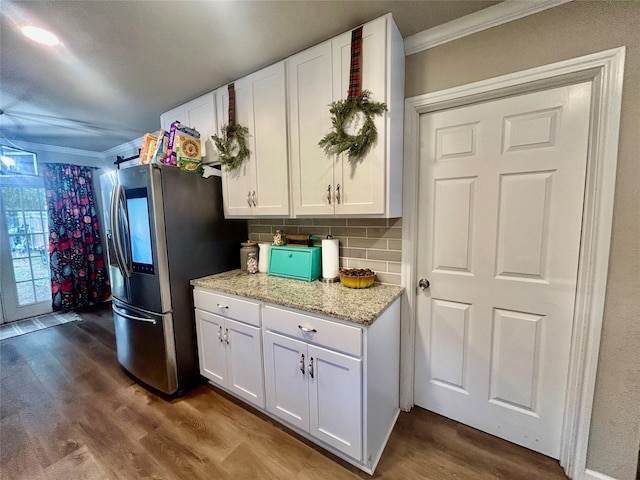 kitchen featuring stainless steel fridge, crown molding, hardwood / wood-style floors, and white cabinets