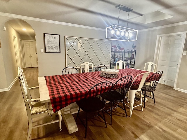 dining room with hardwood / wood-style flooring and crown molding