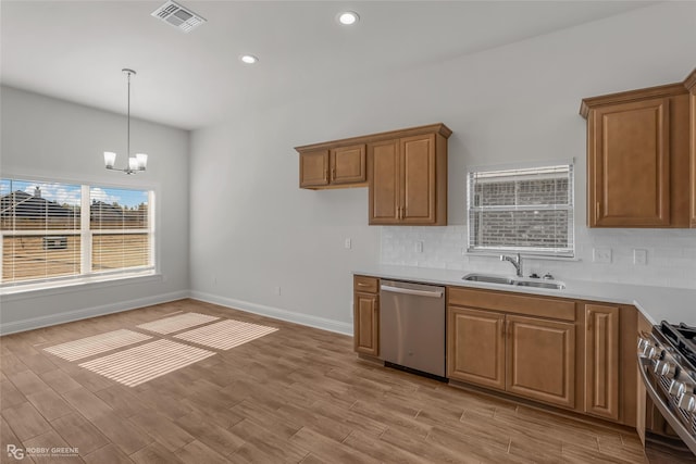 kitchen featuring an inviting chandelier, hanging light fixtures, sink, light wood-type flooring, and appliances with stainless steel finishes