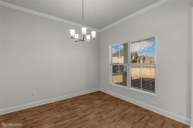 spare room with hardwood / wood-style floors, a notable chandelier, and crown molding