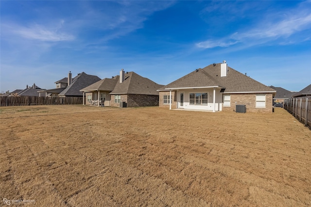 rear view of house featuring a yard and cooling unit