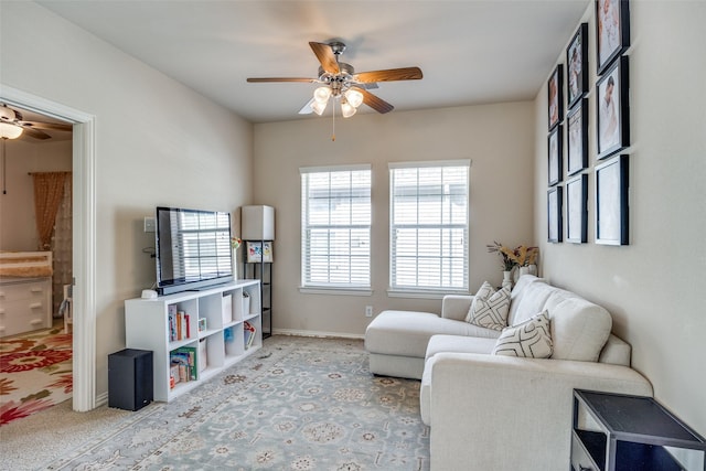 living area with ceiling fan and light colored carpet