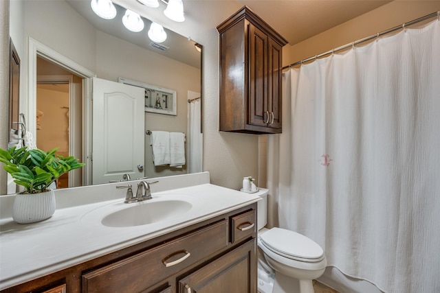 bathroom featuring a shower with shower curtain, vanity, and toilet