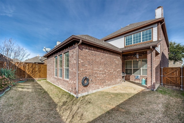 back of house featuring a patio area and a yard