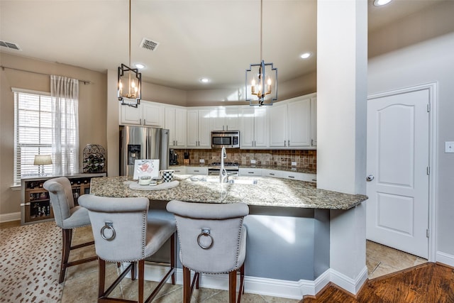 kitchen featuring light stone countertops, white cabinets, and appliances with stainless steel finishes