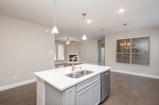 kitchen featuring dark wood-type flooring, sink, stainless steel dishwasher, and a center island with sink