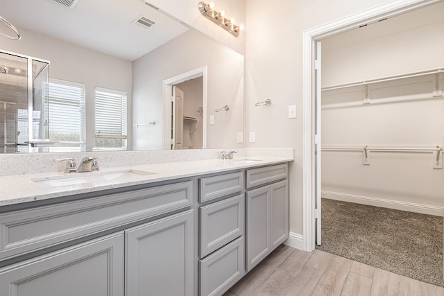 bathroom featuring hardwood / wood-style flooring, vanity, and an enclosed shower