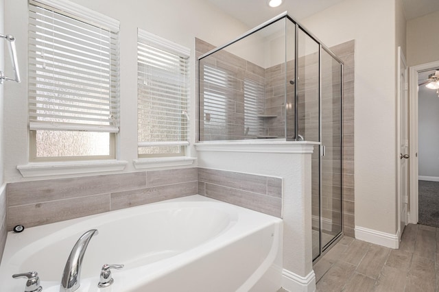 bathroom with wood-type flooring and shower with separate bathtub