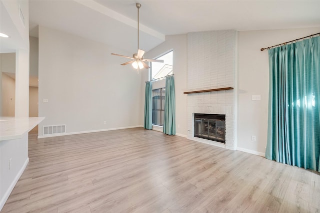 unfurnished living room featuring a fireplace, light hardwood / wood-style floors, and lofted ceiling