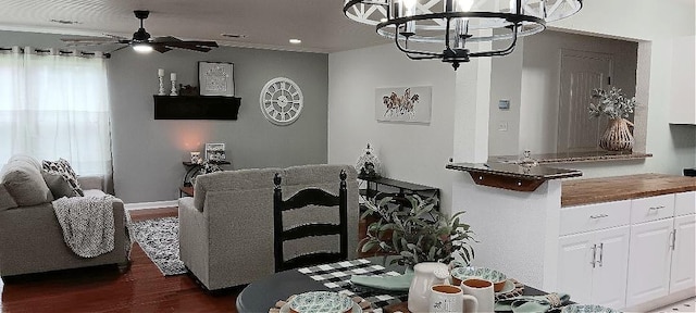 dining area with dark hardwood / wood-style floors and ceiling fan with notable chandelier