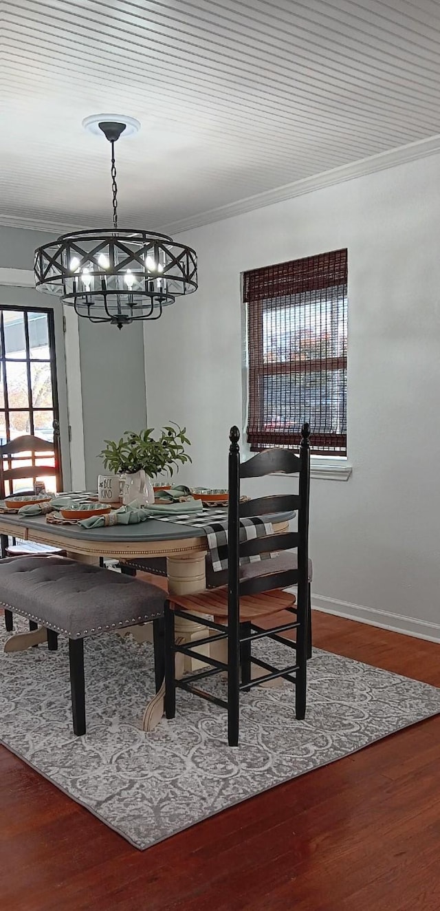 dining room featuring hardwood / wood-style flooring, ornamental molding, and a chandelier