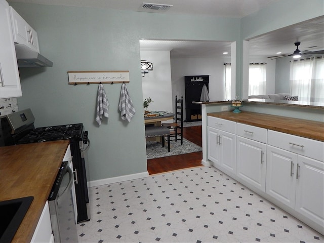 kitchen featuring ceiling fan, stainless steel range with gas cooktop, light hardwood / wood-style flooring, butcher block countertops, and white cabinets