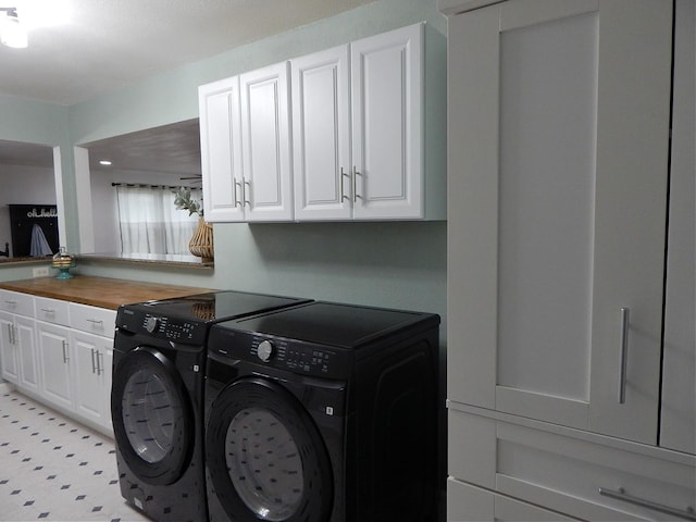 laundry area featuring washer and dryer and cabinets