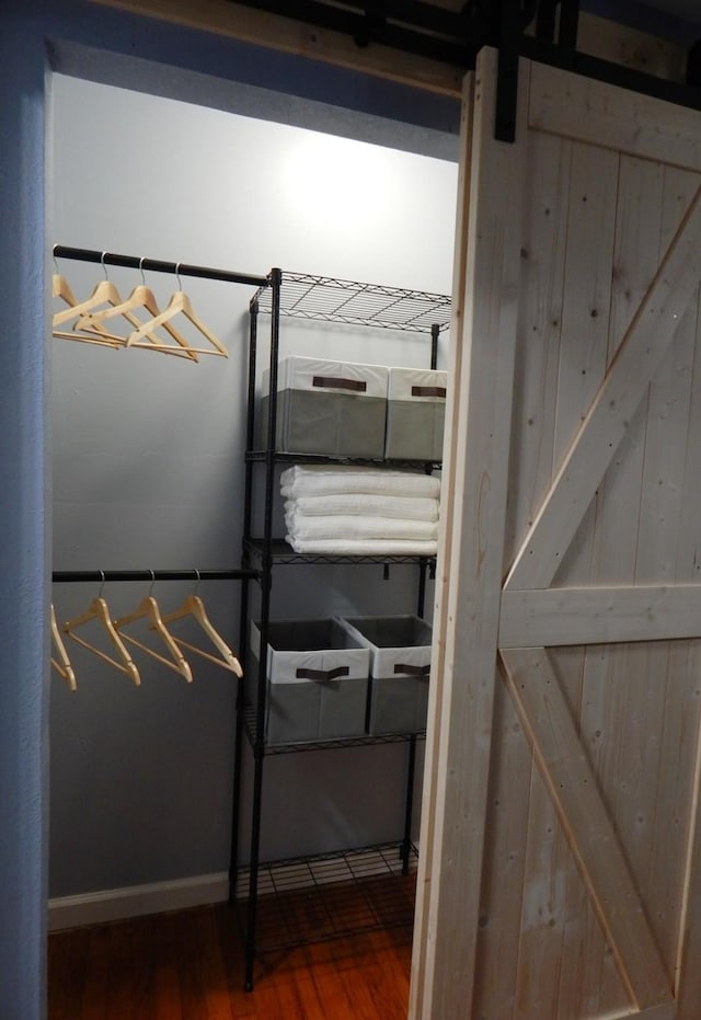 interior space with wood-type flooring and a barn door