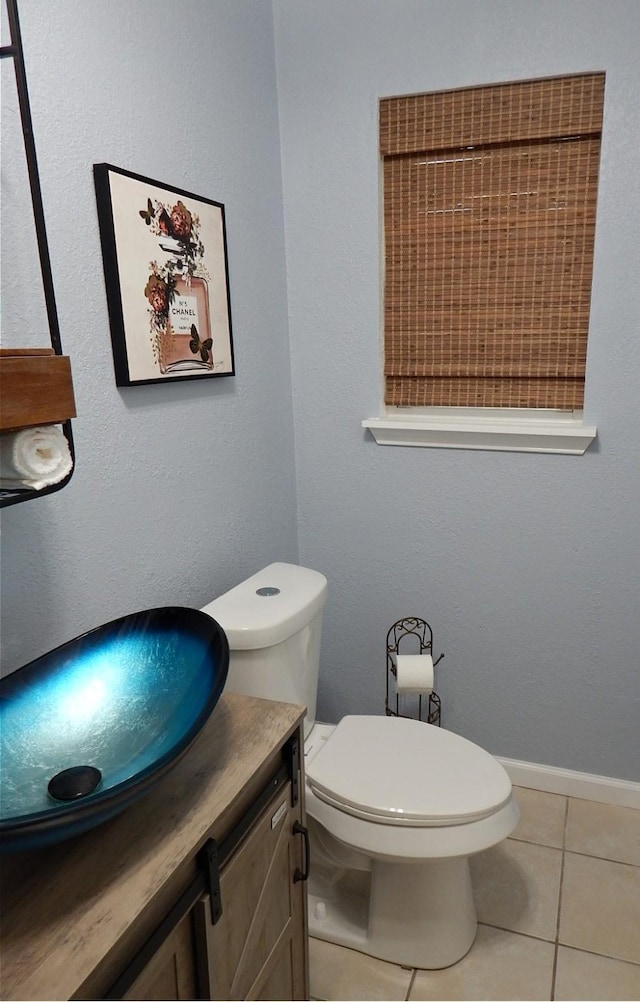 bathroom with tile patterned flooring, vanity, and toilet