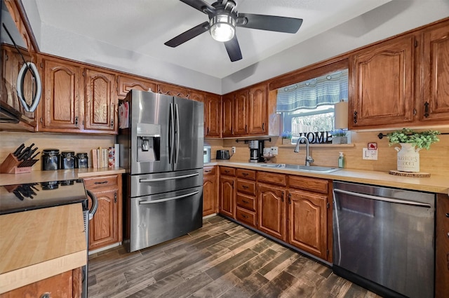 kitchen with dark hardwood / wood-style flooring, tasteful backsplash, stainless steel appliances, ceiling fan, and sink