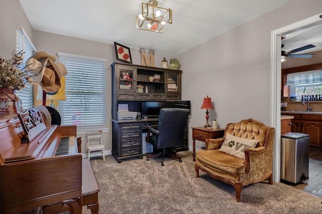 carpeted office space with sink, ceiling fan with notable chandelier, and vaulted ceiling