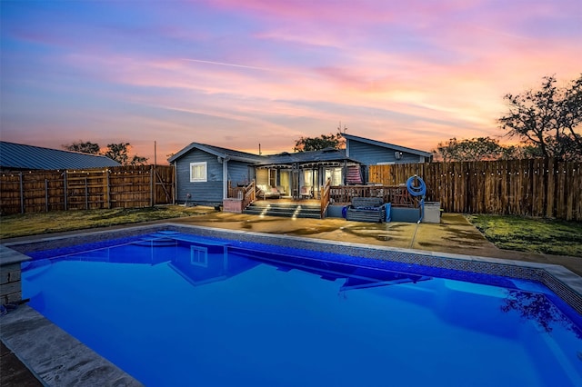 pool at dusk with a patio