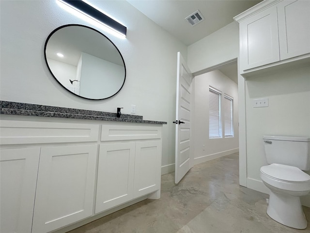 bathroom with vanity, toilet, and concrete flooring