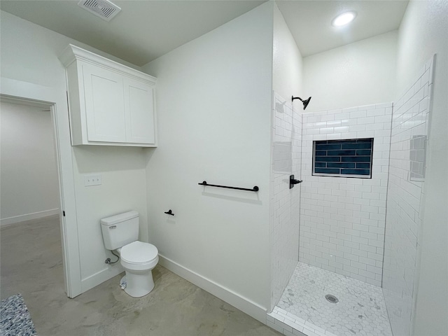 bathroom featuring a tile shower and toilet