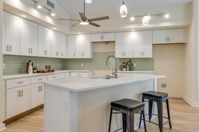 kitchen featuring white cabinetry, a center island with sink, and light hardwood / wood-style floors